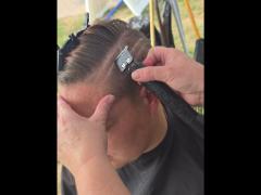 A precise cross beneath a lifted crown braid—faith forward, beautifully worn.