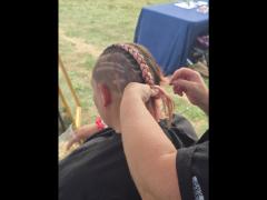 A precise cross beneath a lifted crown braid—faith forward, beautifully worn.