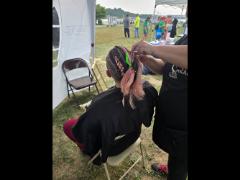 A precise cross beneath a lifted crown braid—faith forward, beautifully worn.