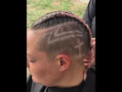 A precise cross beneath a lifted crown braid—faith forward, beautifully worn.