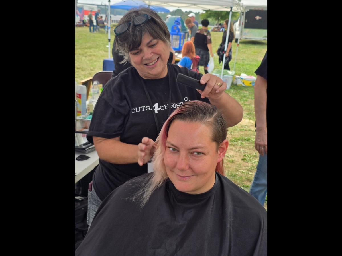 A precise cross beneath a lifted crown braid—faith forward, beautifully worn.