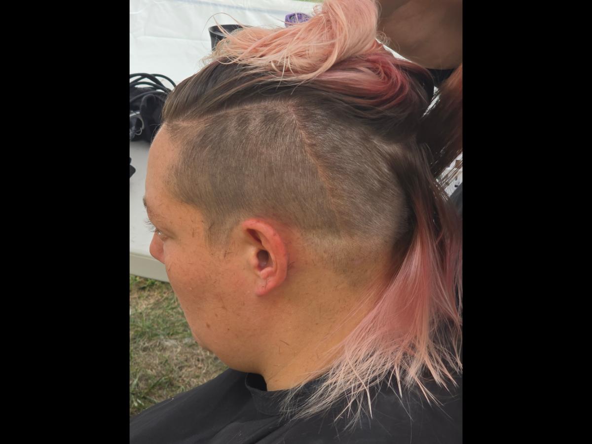 A precise cross beneath a lifted crown braid—faith forward, beautifully worn.