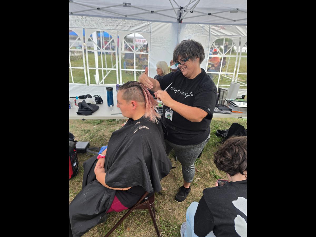 A precise cross beneath a lifted crown braid—faith forward, beautifully worn.