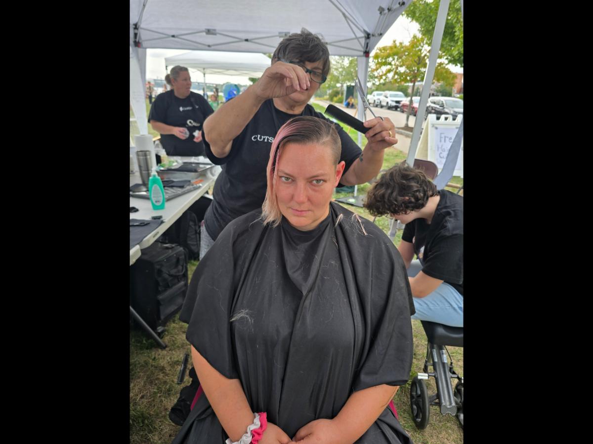 A precise cross beneath a lifted crown braid—faith forward, beautifully worn.