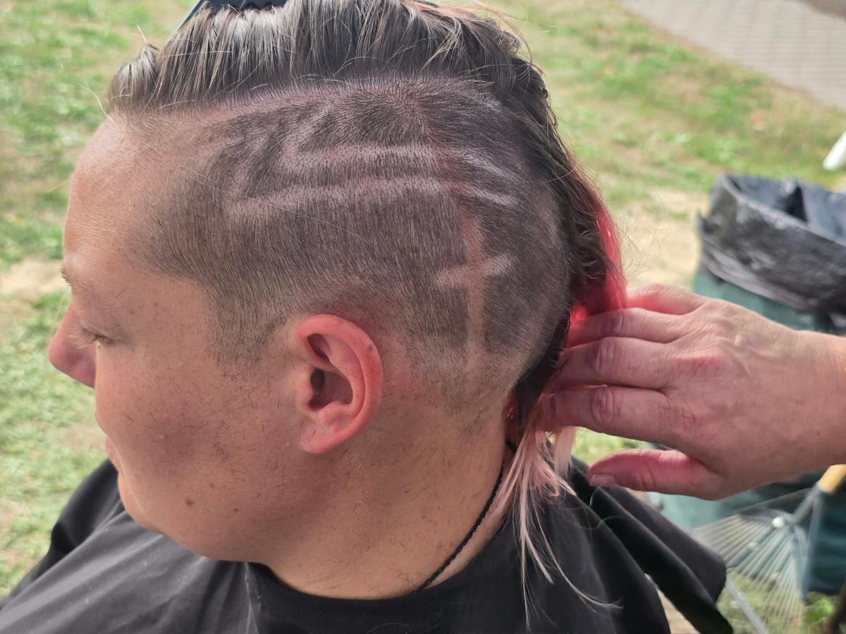 A precise cross beneath a lifted crown braid—faith forward, beautifully worn.