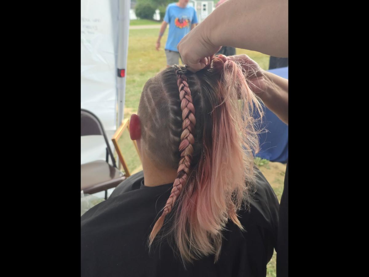 A precise cross beneath a lifted crown braid—faith forward, beautifully worn.