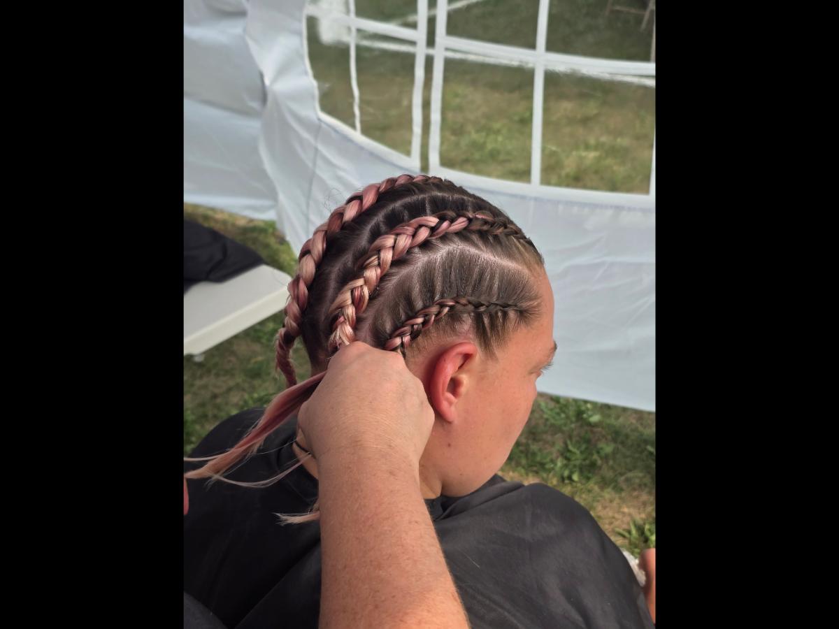 A precise cross beneath a lifted crown braid—faith forward, beautifully worn.