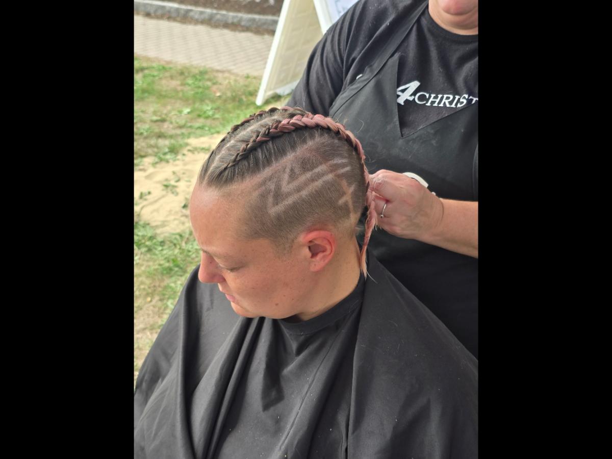 A precise cross beneath a lifted crown braid—faith forward, beautifully worn.