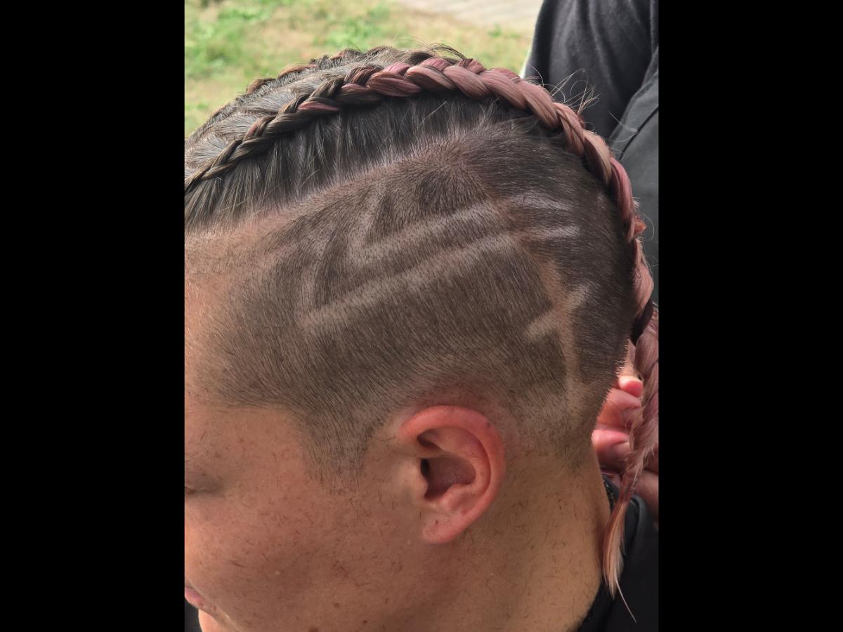 A precise cross beneath a lifted crown braid—faith forward, beautifully worn.