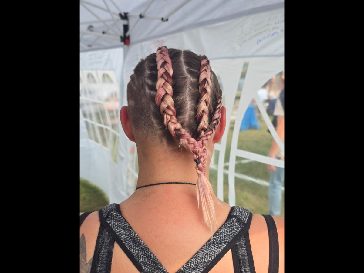 A precise cross beneath a lifted crown braid—faith forward, beautifully worn.