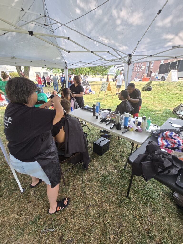 Cuts 4 Christ mobile hair salon ministry providing free haircuts in Maine getting all kinds of haircuts done out in the sun at davenport park in Bangor