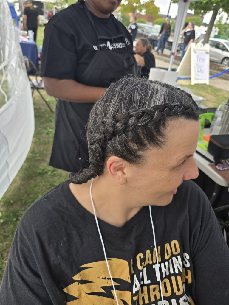 Close-up of finished braid hairstyle at outreach event
