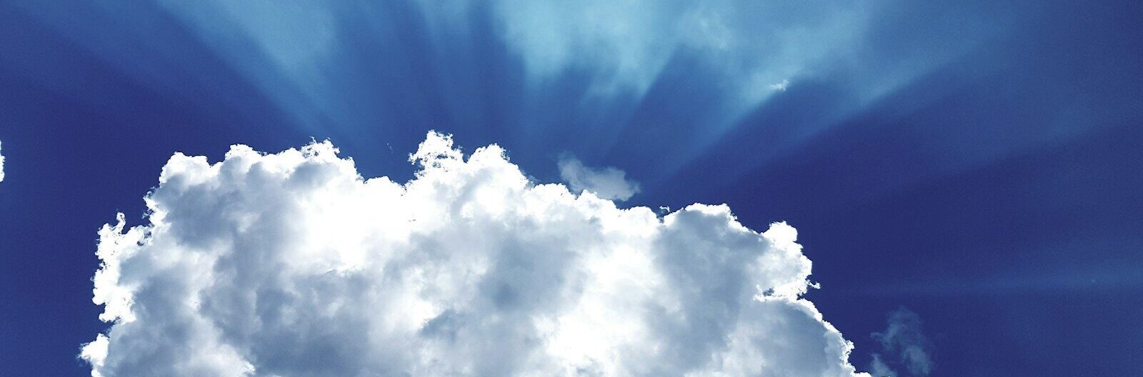 sun rays through white cumulus clouds